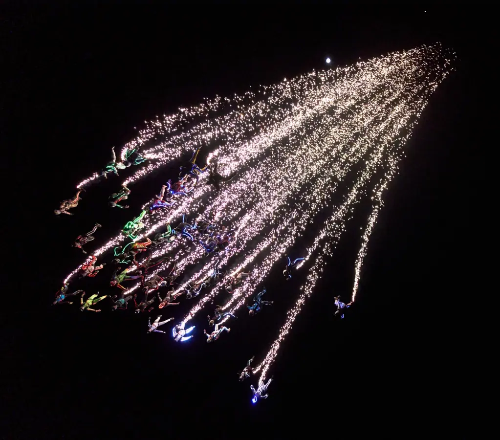 Saut de nuit avec traînées pyrotechniques